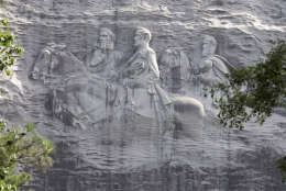 FILE - A June 23, 2015 file photo shows a carving depicting confederates Stonewall Jackson, Robert E. Lee and Jefferson Davis, in Stone Mountain, Ga. A proposed tribute to the Rev. Martin Luther King Jr. atop Stone Mountain has made unlikely allies of civil rights organizations and members of a Confederate heritage group. Both are displeased with state officials plan to use a replica Liberty Bell honoring King at the state park in suburban Atlanta. (AP Photo/John Bazemore, File)