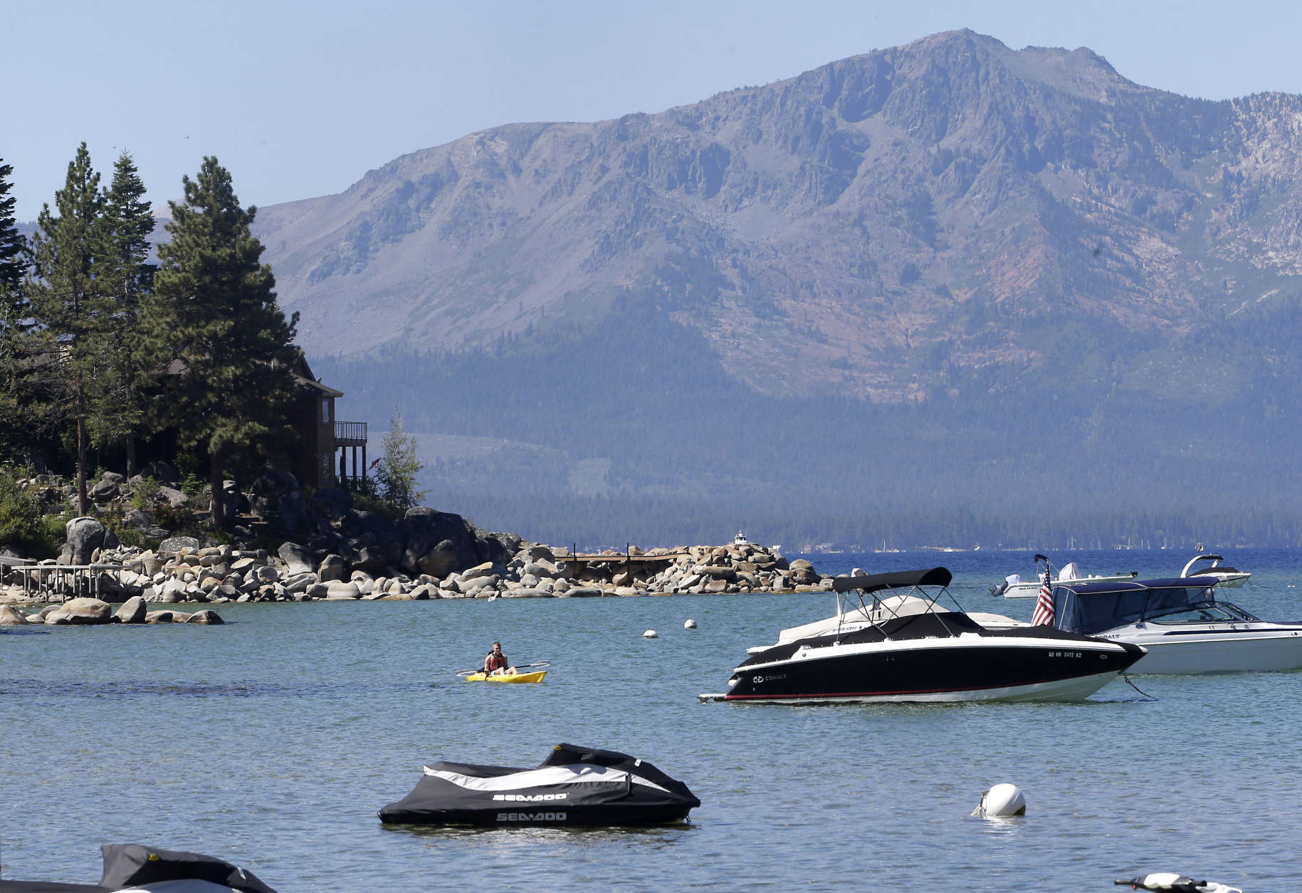 FILE -- In this Aug. 24, 2015 file photo, a kayaker paddles along Zephyr Cove, the sight of the 19th Annual Lake Tahoe Summit Monday, Aug. 24, 2015.  The summit brought together lawmakers,  including Calif. Gov. Jerry Brown, U.S. Sens. Dean Heller, R-Nev., and Dianne Feinstein, D-Calif., other government officials, , business leaders and environmentalists to  the the two-day summit to discuss this years theme, "Connecting Lake Tahoe's Environment and Economy throughout Innovation and Transportation."  Brown has made climate change the centerpiece of his final tenure by trying to reduce California's carbon footprint and boost the state's renewable energy use to 50 percent in 15 years, if he can get it approved by fellow Democrats in the state Legislature.(AP Photo/Rich Pedroncelli, file)