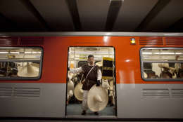 A member of the military, wearing a costume representing the 1911 revolutionary forces, stands at the door of the subway on his way to downtown Mexico City, prior to the military parade of the Independence Day celebrations, Mexico City, Sunday Sept. 16, 2012. Mexico celebrates the 202nd anniversary of its 1810 independence uprising. (AP Photo/Alexandre Meneghini)