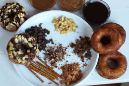 This photo taken Nov. 2, 2015, features an array of toppings for doughnuts including pretzels, dried fruits, toasted nuts, toasted coconut, crushed cereal and crushed cookies, peanut butter, chocolate glaze and caramel sauce. Most everybody loves fresh, warm doughnuts. But most everybody doesnt love the hassle of making those fresh, warm doughnuts. Its a messy process that involves making a dough that can be temperamental. (AP Photo/Matthew Mead)