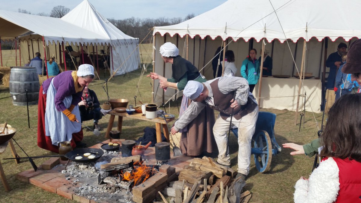 Actors prepare hoecakes for guests. (WTOP/Kathy Stewart)