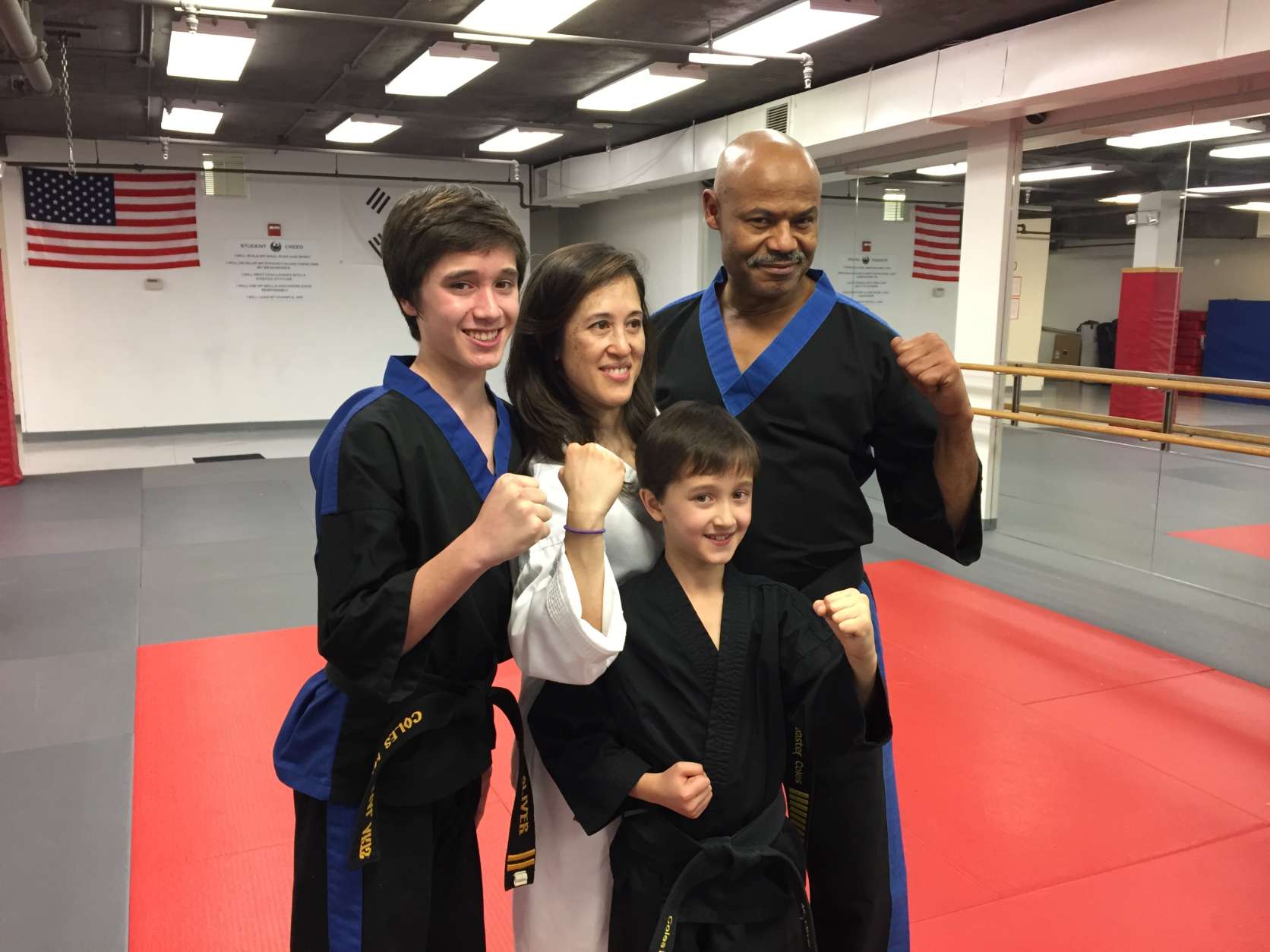 Melissa Marquez and her sons pose with Master Michael Coles of Coles Martial Arts Academy in Bethesda, Md. (WTOP/Michelle Basch)