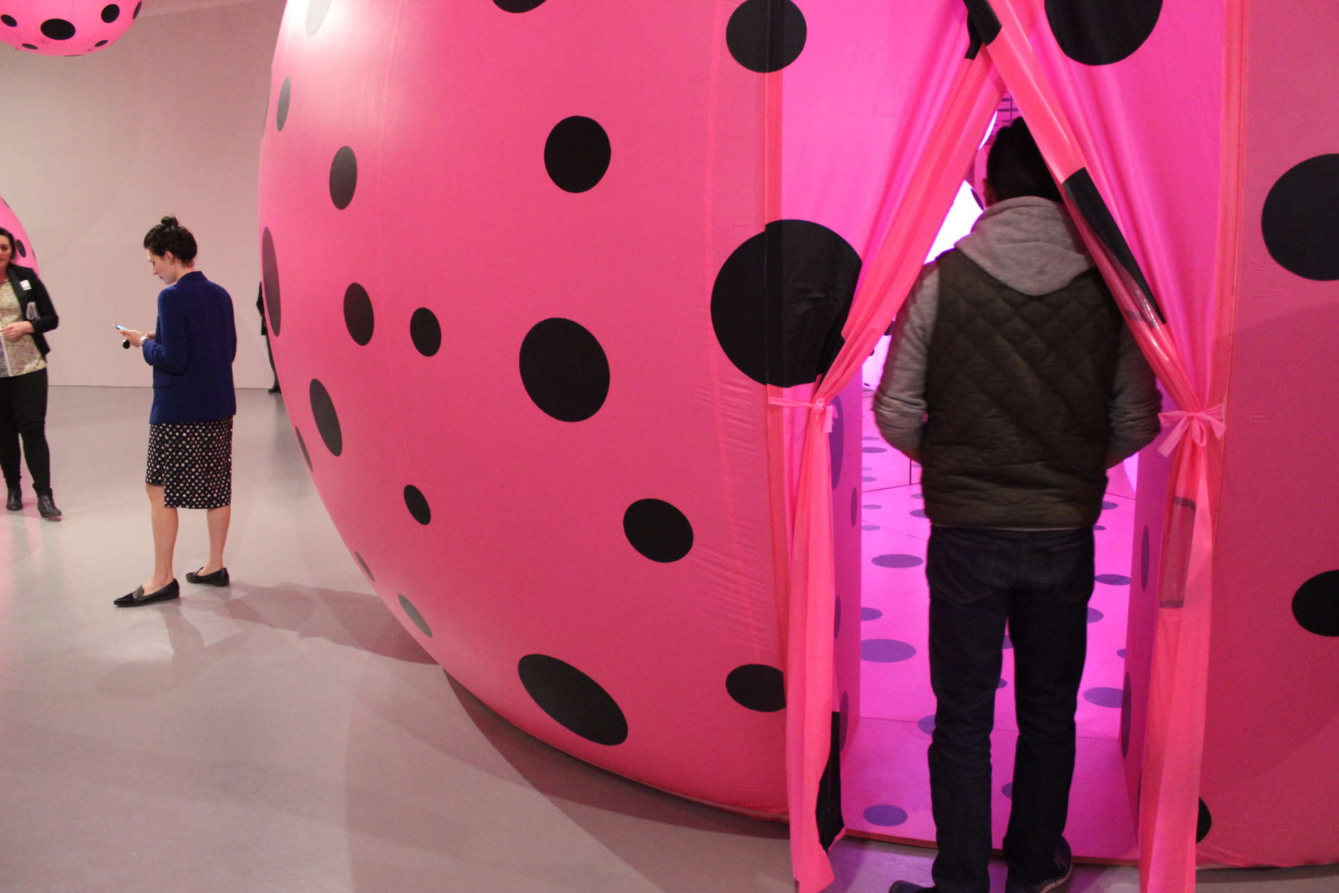The entrance into one of the mirrored rooms where visitors will find a series of spotted pink orbs. (WTOP/Megan Cloherty)