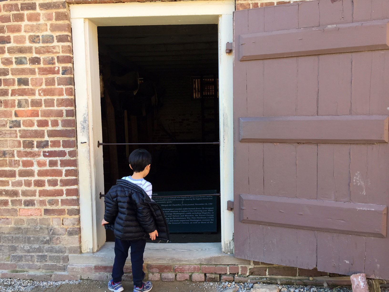 A young boy looks into a stable at Mount Vernon on Monday, Feb. 20, 2017. interior and ext of the blacksmith shop, all rising for the National Anthem at the start of the ceremony.