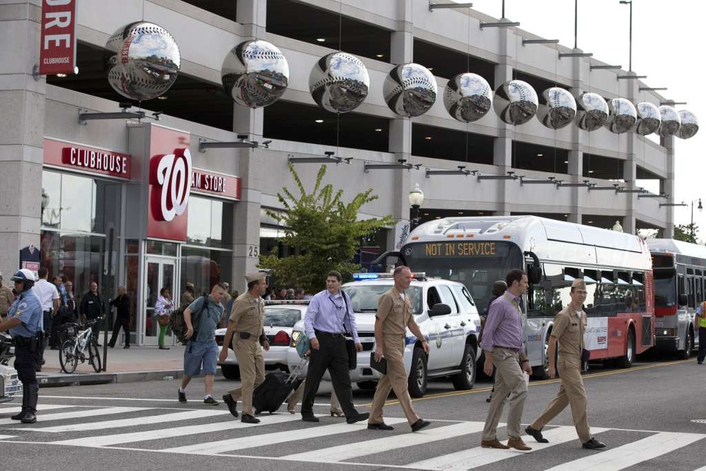 Staff of the Naval Sea Systems Command headquarters walk away from Nationals Park after being bused there from the Washington Navy Yard. (AP Photo/Jacquelyn Martin)