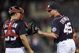 Washington Nationals relief pitcher Blake Treinen (45) celebrates with catcher Jose Lobaton (59) after the Nationals defeated the Minnesota Twins 8-4 in a baseball game Friday, April 22, 2016, in Washington. (AP Photo/Nick Wass)