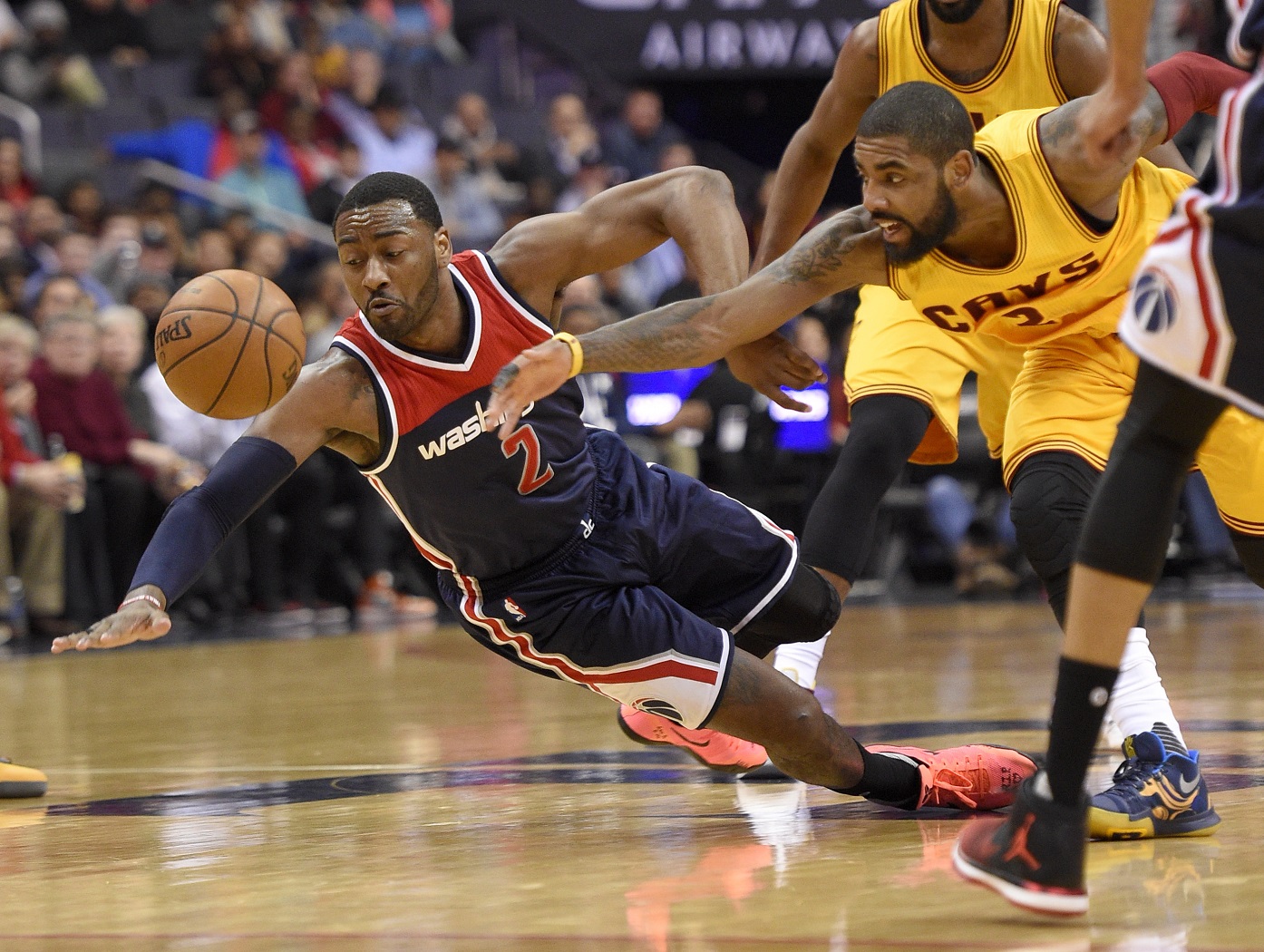 Washington Wizards guard John Wall, left, dives for a loose ball against Cleveland Cavaliers guard Kyrie Irving, right, during the first half of an NBA basketball game, Monday, Feb. 6, 2017, in Washington. (AP Photo/Nick Wass)