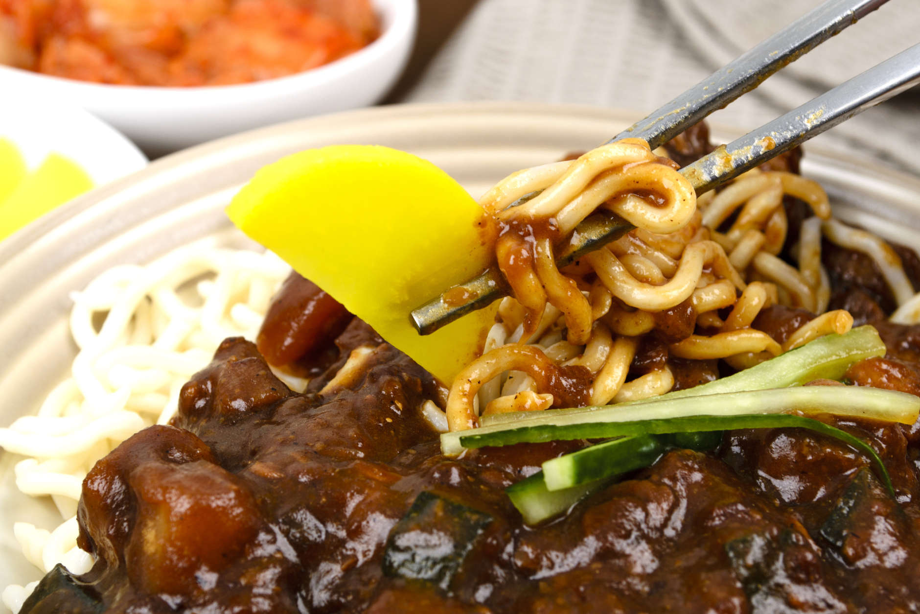 Korean / Chinese pork and vegetable noodles in black bean sauce served with danmuji and kimchi.