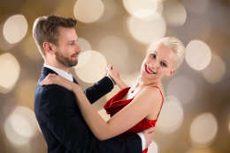 Portrait Of Young Happy Couple Dancing On Bokeh Background
