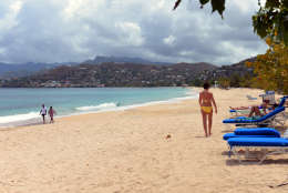 In this April 25, 2013 photo, tourists walk on the white sand of the Grand Anse Beach, Grenada. The people along this vulnerable stretch of eastern Grenada have been watching the sea eat away at their shoreline in recent decades, a result of destructive practices such as sand mining and a ferocious storm surge made worse by climate change, according to researchers with the U.S.-based Nature Conservancy, who have helped locals map the extent of coastal erosion. (AP Photo/David McFadden)