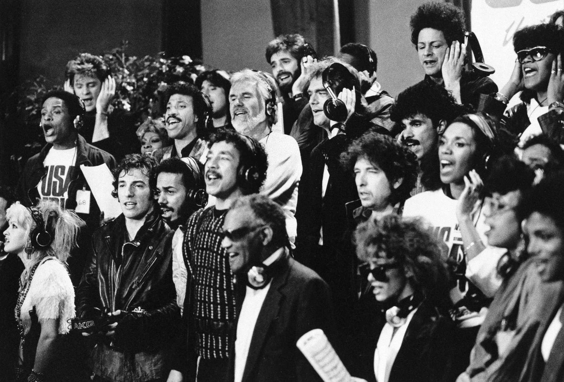 Some of a group of 45 music artists calling themselves "USA For Africa" recording "We Are The World" in Los Angeles, Calif.  Jan. 30, 1985. Bottom row, from left; Cyndi Lauper, Bruce Springsteen, James Ingram, Smokey Robinson, Ray Charles, Sheila E., June Pointer, Randy Jackson. Middle row, from left; Al Jarreau, Dionne Warwick, Lionel Richie, Kenny Rogers, Huey Lewis, Bob Dylan, John Oates, Ruth Pointer. Top row, from left; Daryl Hall, Steve Perry, Kenny Loggins, Jeffrey Osborne, Lindsay Buckingham, and Anita Pointer.  (AP Photo)