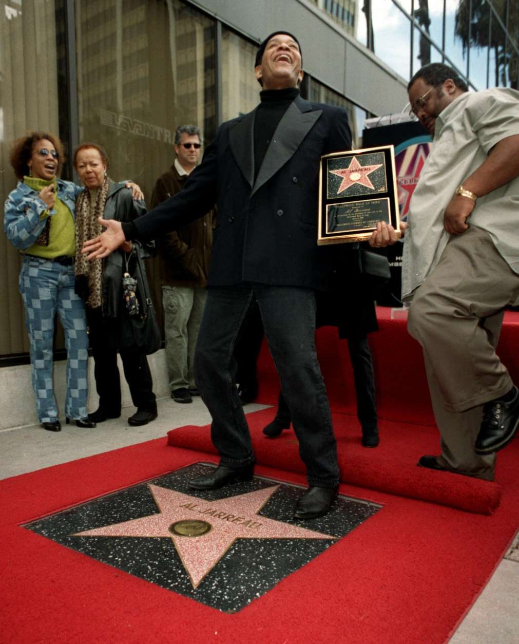 Grammy award winning singer Al Jarreau, center, celebrates with family and friends after he was honored the 2,174th star on the Hollywood Walk of Fame, Tuesday, March 6, 2001, in Los Angeles. (AP Photo/Patrick Liotta)