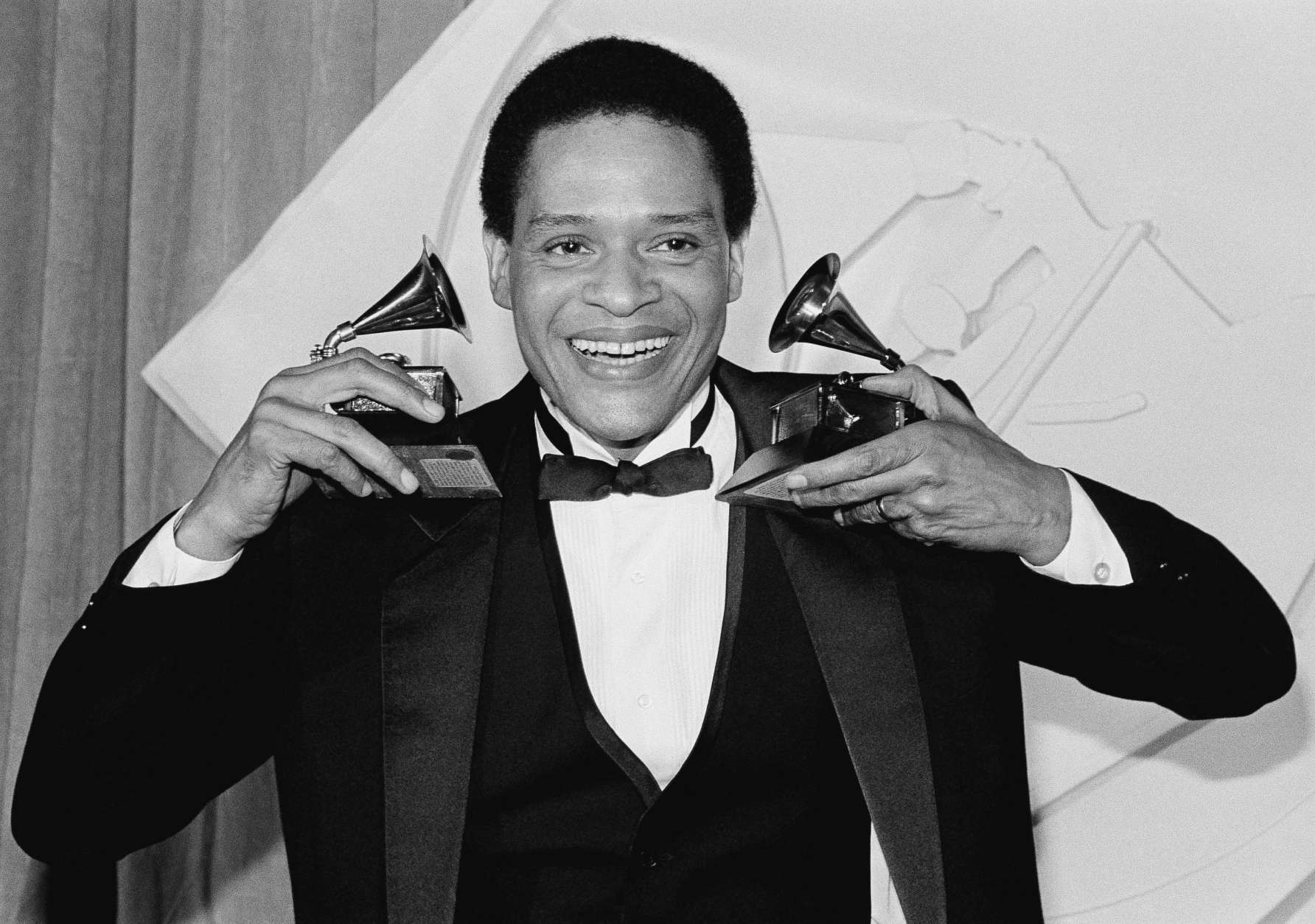 Singer Al Jarreau has more than an earful as he holds up his Grammy he won during the 24th annual Grammy Awards presentation in Los Angeles Wednesday night, Feb. 25, 1982. Jarreau won the honors for best pop male vocalist and best jazz male vocalist. (AP Photo/Reed Saxon)