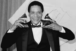 Singer Al Jarreau has more than an earful as he holds up his Grammy he won during the 24th annual Grammy Awards presentation in Los Angeles Wednesday night, Feb. 25, 1982. Jarreau won the honors for best pop male vocalist and best jazz male vocalist. (AP Photo/Reed Saxon)