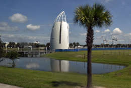 Road approching space center with blue sky, reflections and cruise ship in background