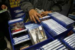 In this photo made Friday, Nov. 27, 2009, customers brows Blu-ray movies at Best Buy in West Hollywood, Calif. Although prices for some Blu-ray players dropped below $100 this holiday season, customers are hesitating to jump into the next-generation video format. (AP Photo/Jason Redmond)