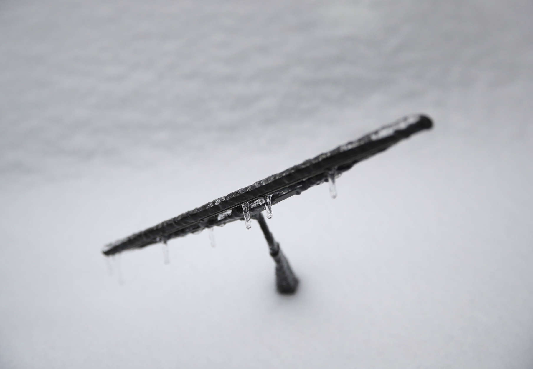 Ice sticks to a windshield wiper that was propped up overnight in advance of a winter storm moving through Baltimore, Tuesday, March 14, 2017. (AP Photo/Patrick Semansky)