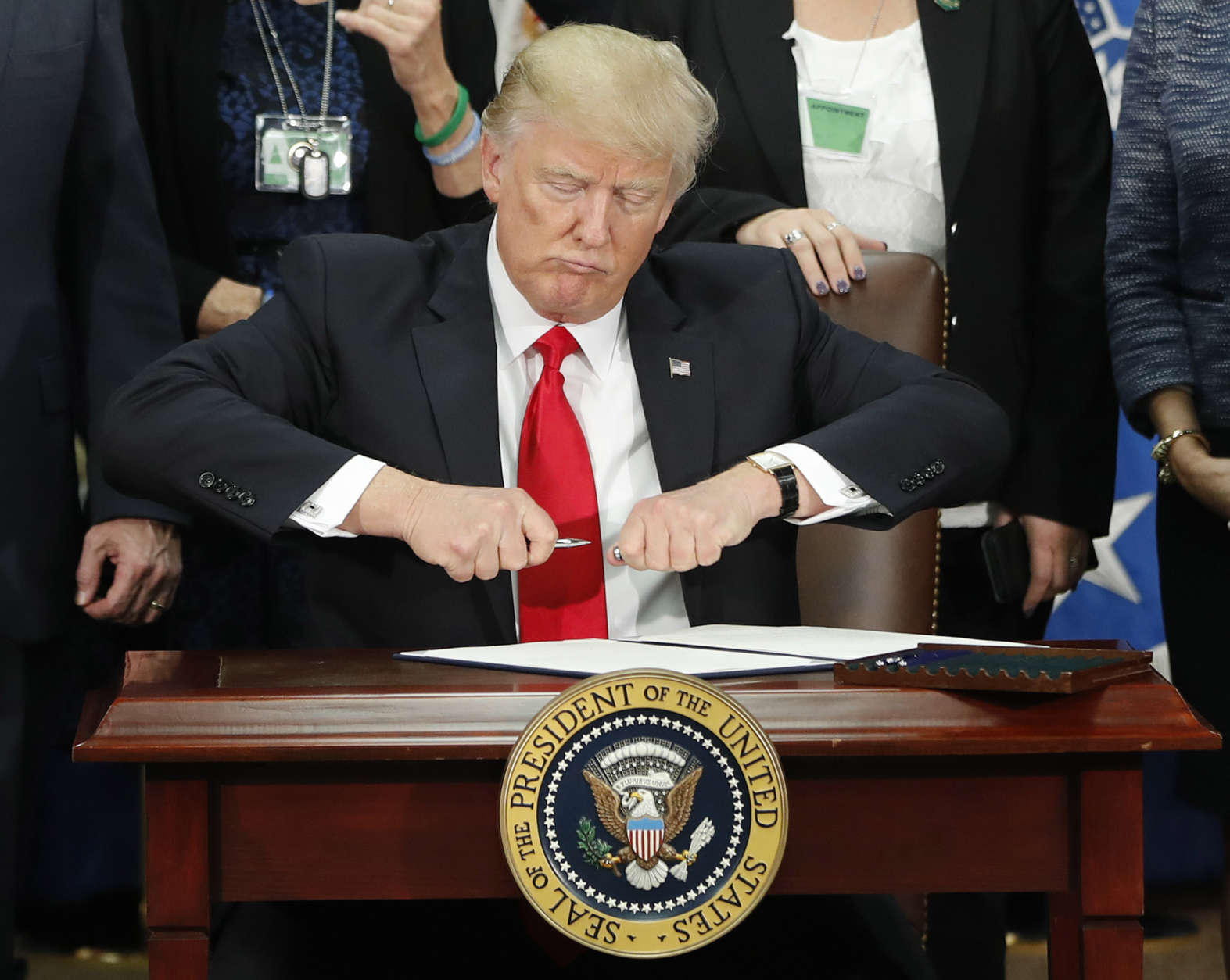 President Trump takes the cap off a pen before signing an executive order on building border wall during a visit to the Homeland Security Department on Jan. 25. (AP photo/Pablo Martinez Monsivais)