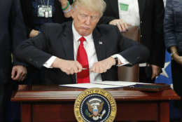 President Trump takes the cap off a pen before signing an executive order on building border wall during a visit to the Homeland Security Department on Jan. 25. (AP photo/Pablo Martinez Monsivais)