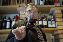 Robert Samek, a sommelier, inspects a glass of red wine at his wine shop in Zagreb, Croatia, Wednesday, March 1, 2017. Slovenian winemakers have warned the EU that Croatia has presented "forged" documents while getting a permission to use the Teran wine brand in the 28-nation bloc. Neighboring EU members Slovenia and Croatia have long been at odds over the use of the Teran red wine name. (AP Photo/Darko Bandic)