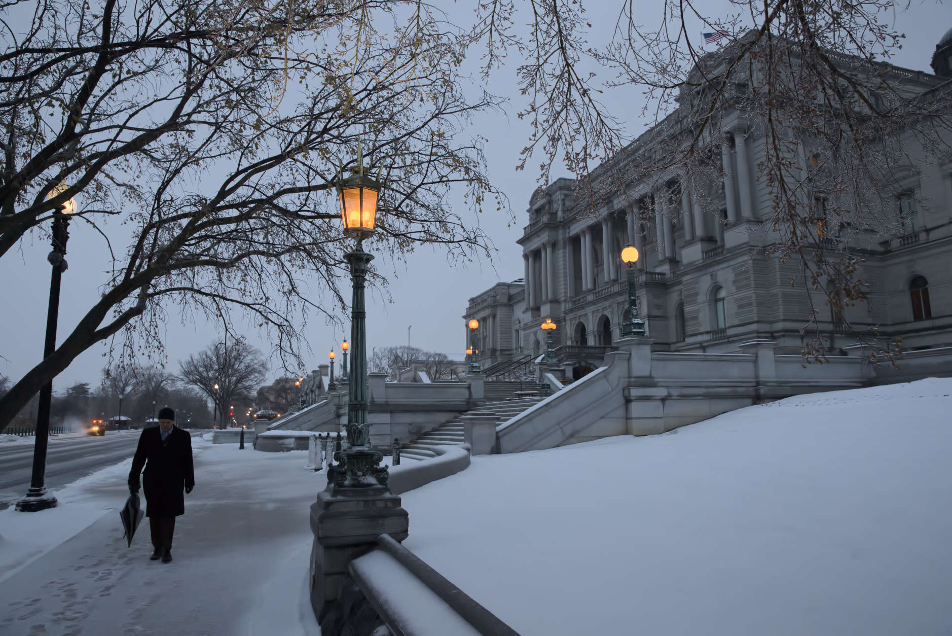 A man walks past the Library of Congress in the snow, on Capitol Hill in Washington, early Tuesday, March, 14, 2017. A late-season storm is dumping a messy mix of snow, sleet and rain on the mid-Atlantic, complicating travel, knocking out power and closing schools and government offices around the region.  (AP Photo/J. Scott Applewhite)