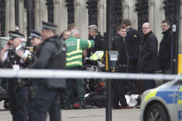 Emergency services work at the scene of a crashed car close to the Houses of Parliament, London, Wednesday, March 22, 2017. London police say officers called to 'firearms incident' on Westminster Bridge, near Parliament. The leader of Britain's House of Commons says a man has been shot by police at Parliament. David Liddington also said there were "reports of further violent incidents in the vicinity."  London's police said officers had been called to a firearms incident on Westminster Bridge, near the parliament. Britain's MI5 says it is too early to say if the incident is terror-related.(Yui Mok/PA via AP)