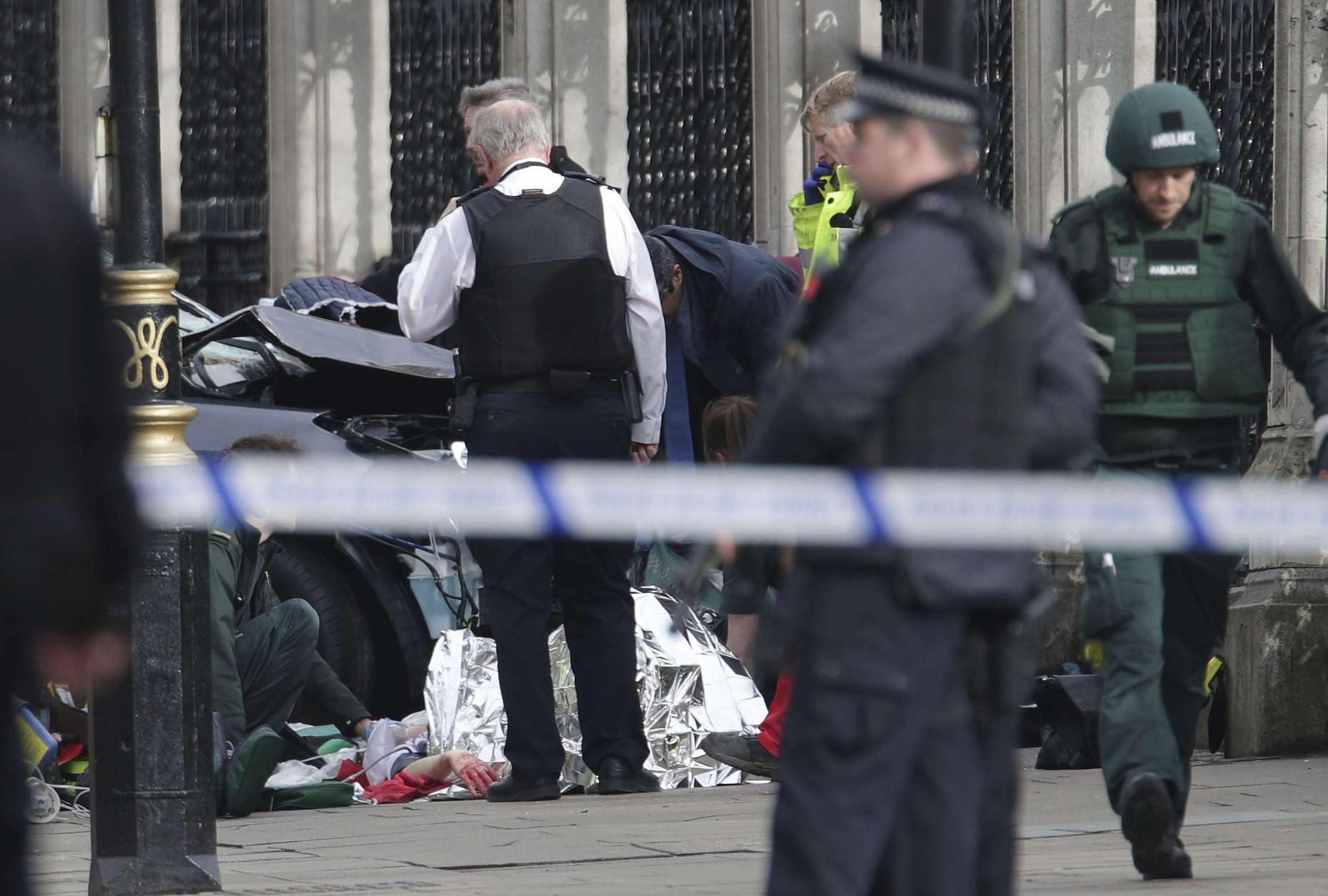 Emergency personnel tend to an injured person close to the Palace of Westminster, London, Wednesday, March 22, 2017.  London police say officers called to a 'firearms incident' on Westminster Bridge, near Parliament. The leader of Britain's House of Commons says a man has been shot by police at Parliament. David Liddington also said there were "reports of further violent incidents in the vicinity."  London's police said officers had been called to a firearms incident on Westminster Bridge, near the parliament. Britain's MI5 says it is too early to say if the incident is terror-related. (Yui Mok/PA via AP).