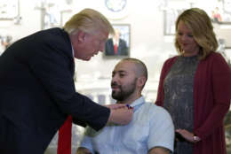 President Trump awards a Purple Heart to U.S. Army Sgt. First Class Alvaro Barrientos as wife Tammy Barrientos watches at Walter Reed National Military Medical Center on April 22. (AP photo/Alex Brandon)
