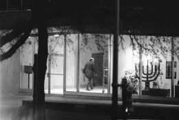 A policeman carries a shotgun as he walks inside BNai BRith headquarters in Washington on Thursday, March 10, 1977 where gunmen are holding people hostage. At right is a Menorah, holy candelabra. (AP Photo/Charles Tasnadi)