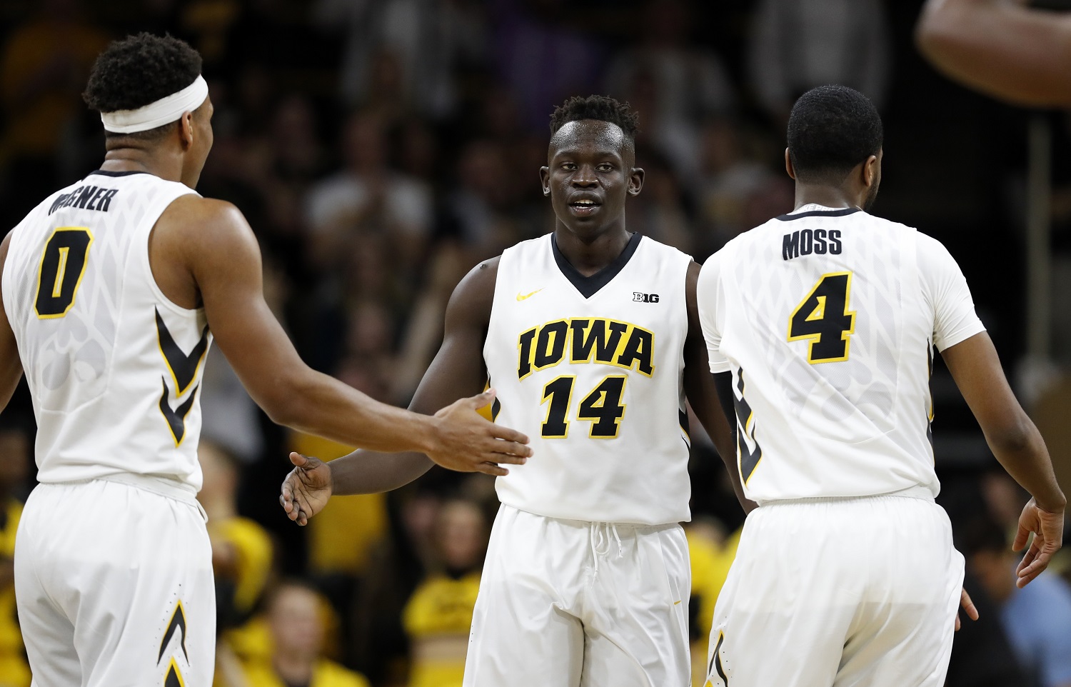 Iowa guard Peter Jok (14) celebrates with teammates Ahmad Wagner, left, and Isaiah Moss, right, during the second half of an NCAA college basketball game, Sunday, March 5, 2017, in Iowa City, Iowa. Iowa won 90-79. (AP Photo/Charlie Neibergall)