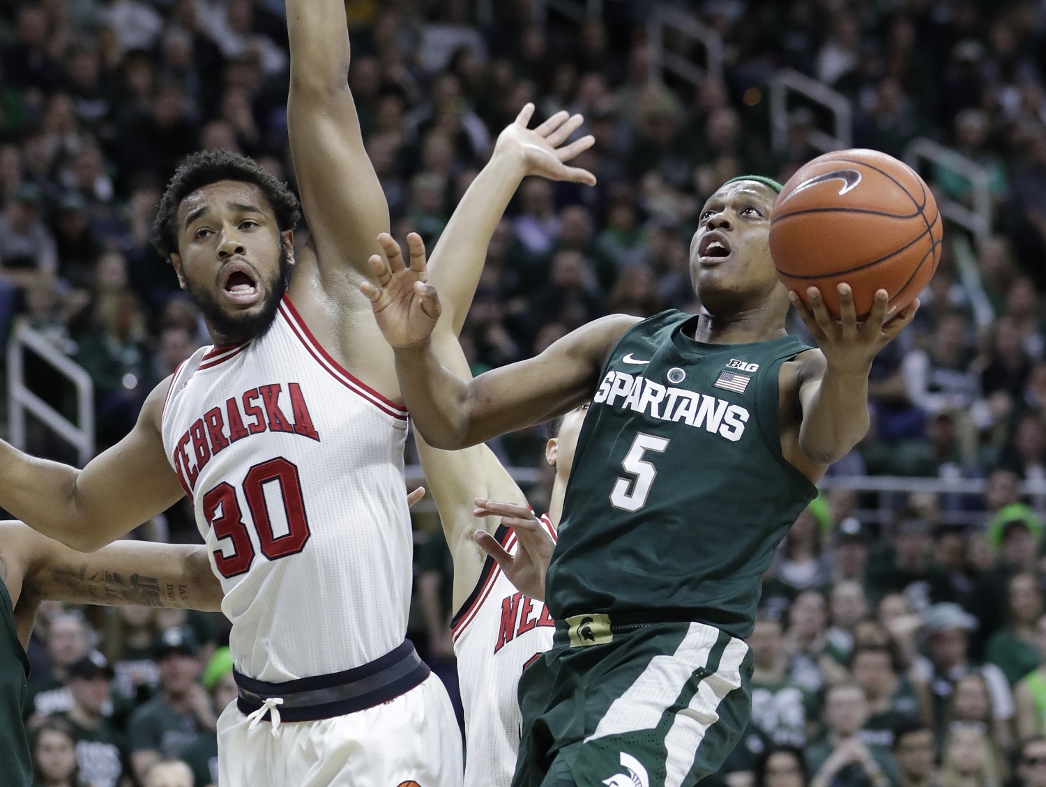 Michigan State guard Cassius Winston (5) makes a layup defended by Nebraska forward Ed Morrow (30) during the second half of an NCAA college basketball game, Thursday, Feb. 23, 2017, in East Lansing, Mich. (AP Photo/Carlos Osorio)