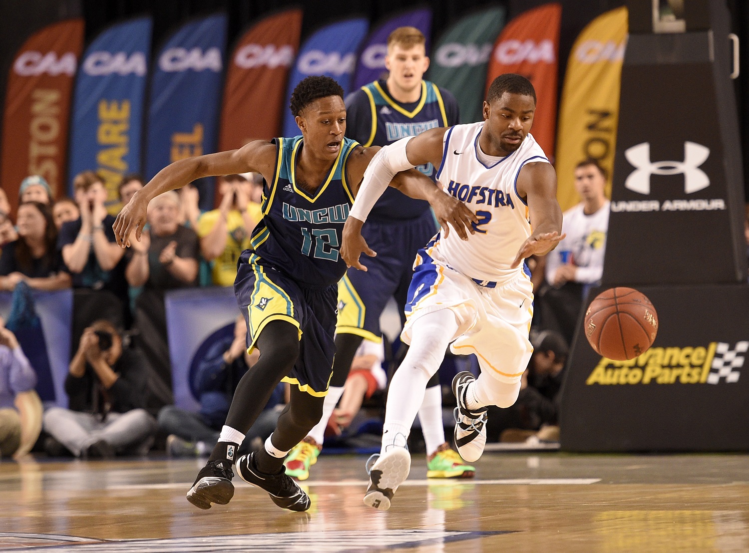 UNC Wilmington guard C.J. Bryce, left, and Hofstra guard Ameen Tanksley (2) chase after the ball during the first half of an NCAA college basketball game in the Colonial Athletic Association championship, Monday, March 7, 2016, in Baltimore. (AP Photo/Nick Wass)