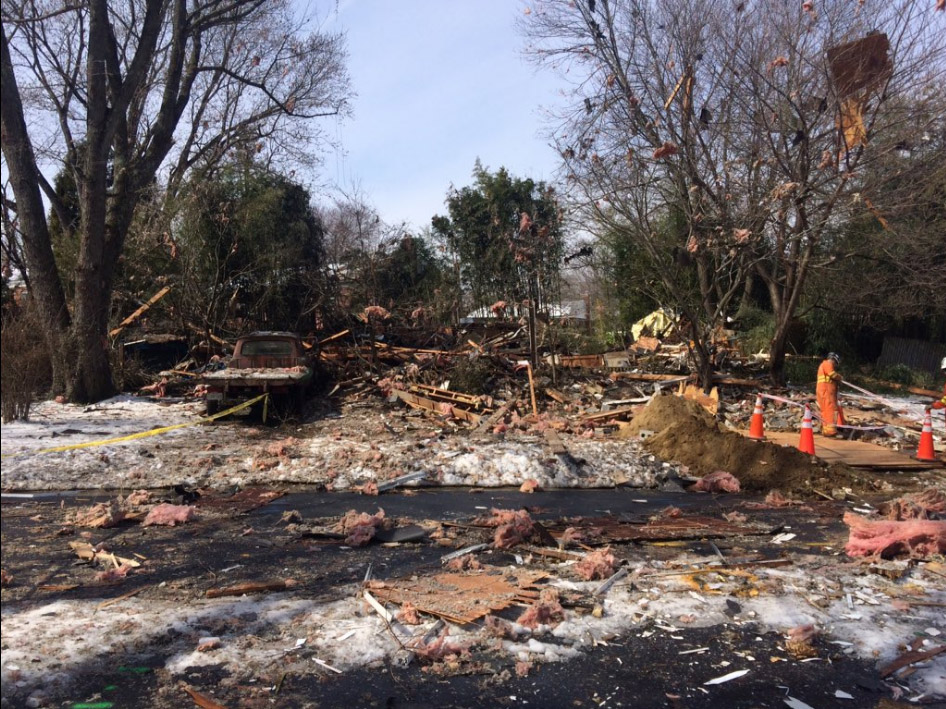 Debris from a house that exploded early Friday morning is seen strewn along tree limbs and power lines and coats the yard and street in front of where the house once stood. A burned out truck sits to left. (Courtesy Montgomery County Fire Rescue)