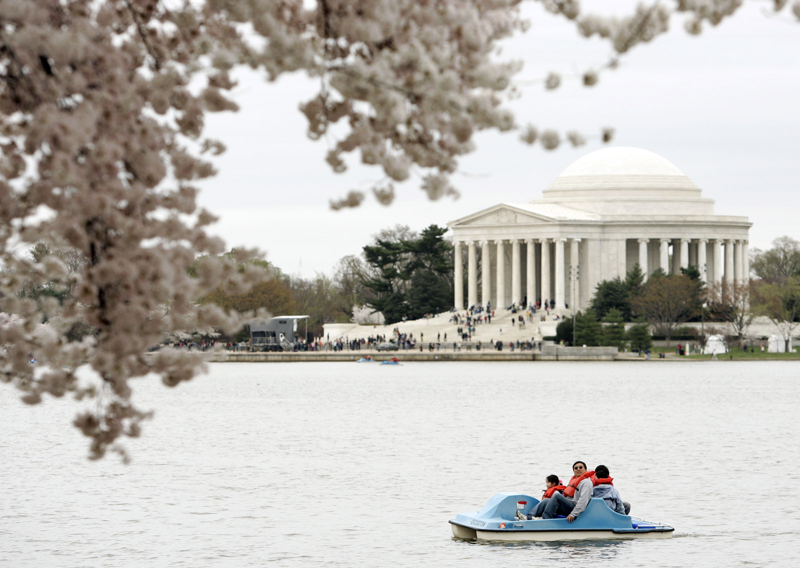 With the Jefferson Memorial in the background, visitors on a paddle boat look at the cherry blossoms along the Tidal Basin Sunday, April 1, 2007 in Washington. (AP Photo/Evan Vucci)