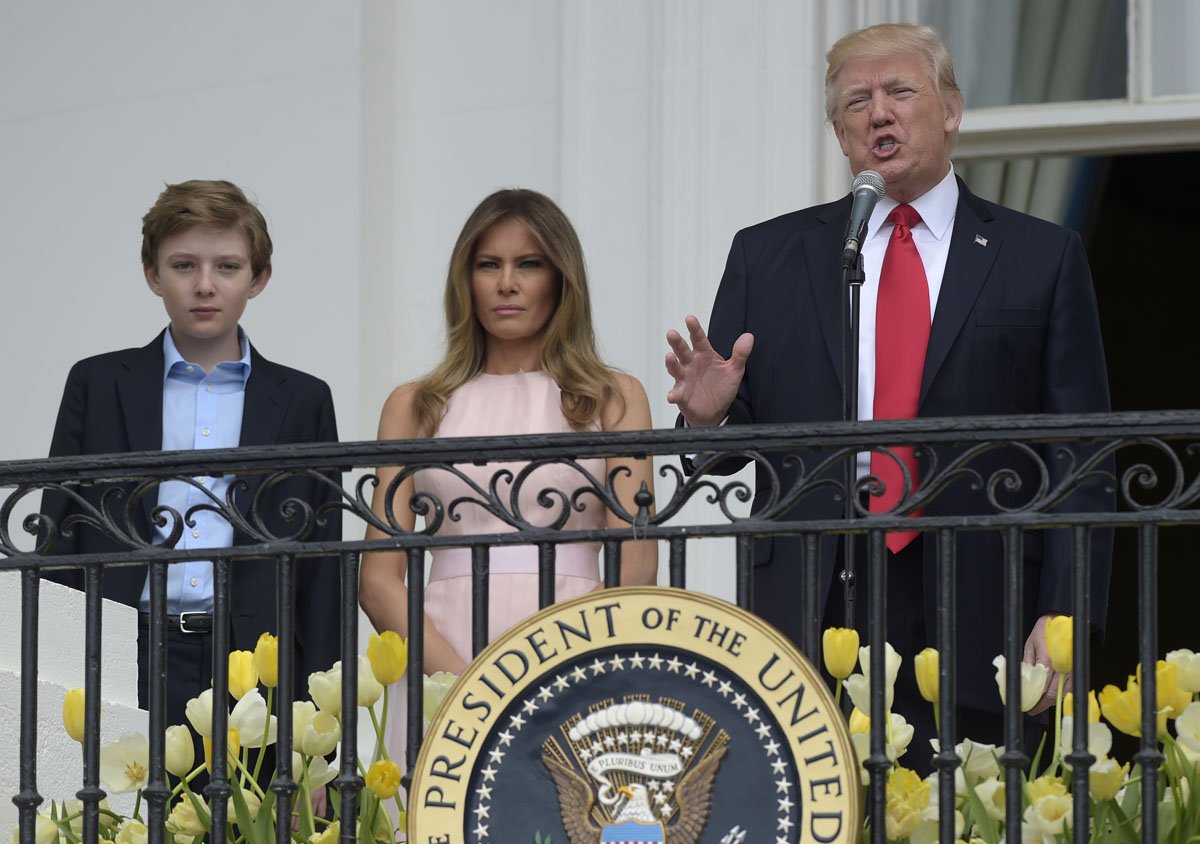 President Donald Trump, with first lady Melania Trump and their son Barron Trump, speaks from the Truman Balcony of the White House in Washington, Monday, April 17, 2017, during the annual White House Easter Egg Roll on the South Lawn.  (AP Photo/Susan Walsh)