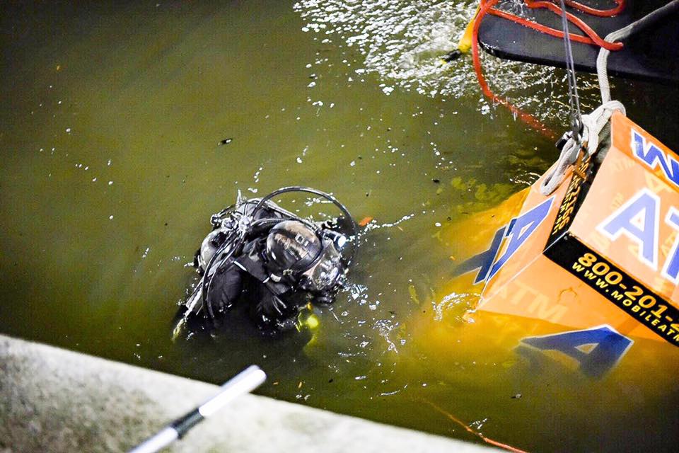 A diver helps get the ATM out of the Baltimore Inner Harbor Thursday. (Courtesy Baltimore police)
