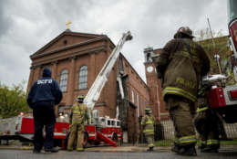 Firefighters work to cut pieces of damaged tin roof down after high winds damaged the roof of St. Aloysius Catholic Church at Gonzaga High School in Washington, Thursday, April 6, 2017.  (AP Photo/Andrew Harnik)