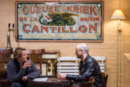 Visitors drink a gueuze beer in the Cantillon gueuze brewery in Brussels, Friday Nov. 6, 2015. One of the most renowned Belgian beer brewers says it is a victim of climate change because increasingly high temperatures shortened the brewing season by a month since the 1950s. The Cantillon gueuze brewery needs to cool its hot brew in open vessels so that the natural yeasts in the air can help produce the sour beer that has developed a niche following throughout the world. (AP Photo/Geert Vanden Wijngaert)