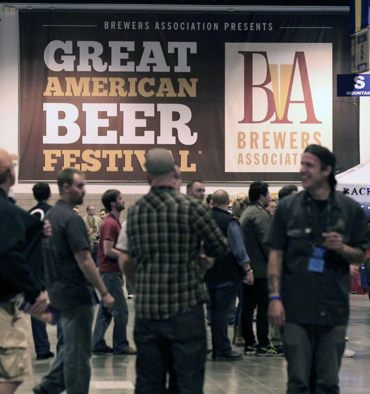 Attendees pass beneath sign at the Great American Beer Festival in the Colorado Convention Center in Denver on Friday, Oct. 12, 2012. Craft beer brewers from around the country have descended on Denver to offer their wares to festival goers as well as take part in competitions. (AP Photo/David Zalubowski)
