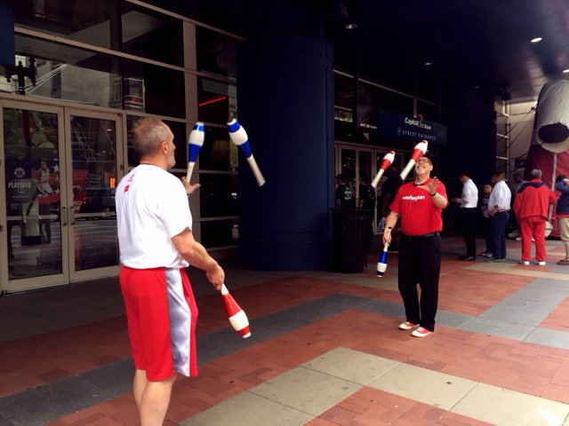 Jugglers entertain the crowds outside the Verizon Center in Washington, D.C. The Wizards and the Celtics play Game 4 of the NBA Playoffs on Sunday, May 7, 2017. (WTOP/Jenny Glick)