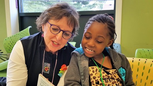 A volunteer with The Reading Connection works with a child at the Wedgewood Apartments in Annandale, Virginia. (Photo courtesy Judy Hijikata)