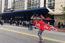 A sign flipper entertains the crowd outside the Verizon Center on Sunday, May 7, 2017. The Wizards and the Celtics play Game 4 of the NBA Playoffs in D.C. (WTOP/Jenny Glick)