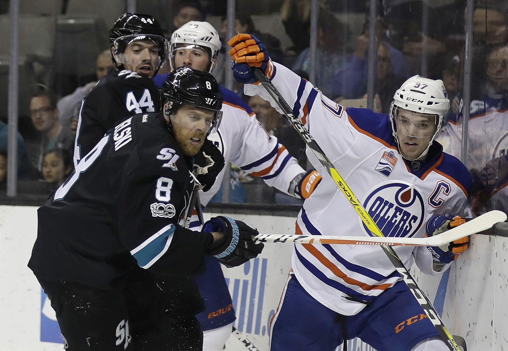 San Jose Sharks' Joe Pavelski (8) pushes Edmonton Oilers' Connor McDavid, right, against the boards during the third period of an NHL hockey game Thursday, April 6, 2017, in San Jose, Calif. (AP Photo/Marcio Jose Sanchez)
