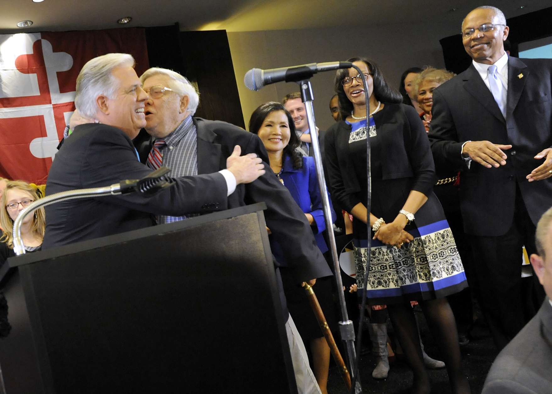 Maryland Gov.-elect Larry Hogan, left, a Republican, hugs his father, former U.S. Congressman Lawrence Hogan, second from left, after beating Democrat Anthony Brown, not pictured, in the state's gubernatorial race Wednesday, Nov. 5, 2014 in Annapolis, Md. Also standing on stage with Hogan are his wife Yumi, third from left, running mate Boyd Rutherford, right, and Rutherford's wife, Monica, second from right. (AP Photo/Steve Ruark)