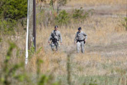 Air Force Security officers patrol the area near the location where a military aircraft crashed, Wednesday, April 5, 2017, in Clinton, Md. The Air Force said that the pilot was on a training mission in an F-16 from the Andrews Air Force-based 113th Wing. Officials say the pilot ejected and is safe. The plane went down a few miles from Andrews. (AP Photo/Pablo Martinez Monsivais)