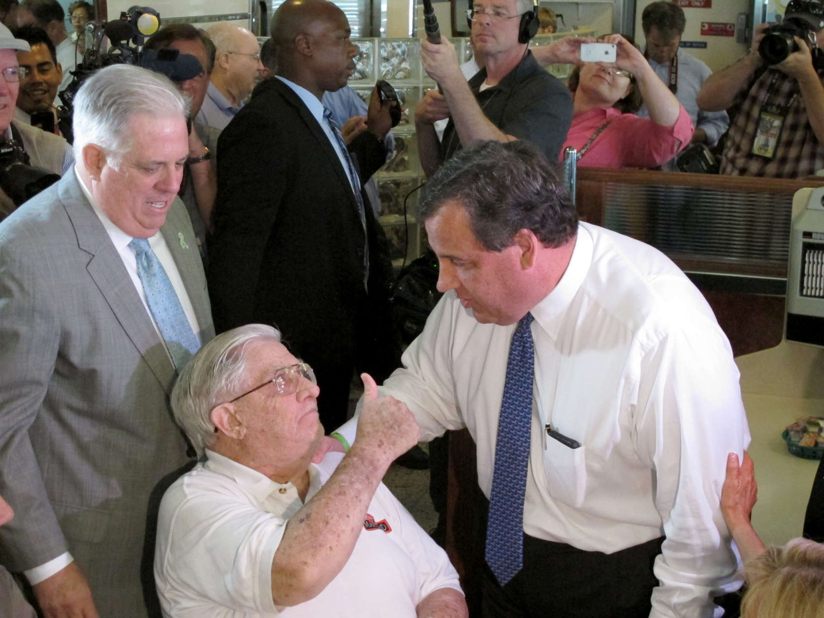 Former Maryland Rep. Larry Hogan, Sr., who is the father of Maryland Gov. Larry Hogan, gives a thumbs up to New Jersey Gov. Chris Christie, who made a campaign stop at a diner near Annapolis, Md., on Wednesday, July 15, 2015. Gov. Hogan, who endorsed Christie's presidential bid, is standing behind his father. (AP Photo/Brian Witte)
