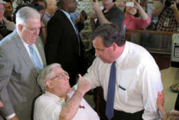 Former Maryland Rep. Larry Hogan, Sr., who is the father of Maryland Gov. Larry Hogan, gives a thumbs up to New Jersey Gov. Chris Christie, who made a campaign stop at a diner near Annapolis, Md., on Wednesday, July 15, 2015. Gov. Hogan, who endorsed Christie's presidential bid, is standing behind his father. (AP Photo/Brian Witte)