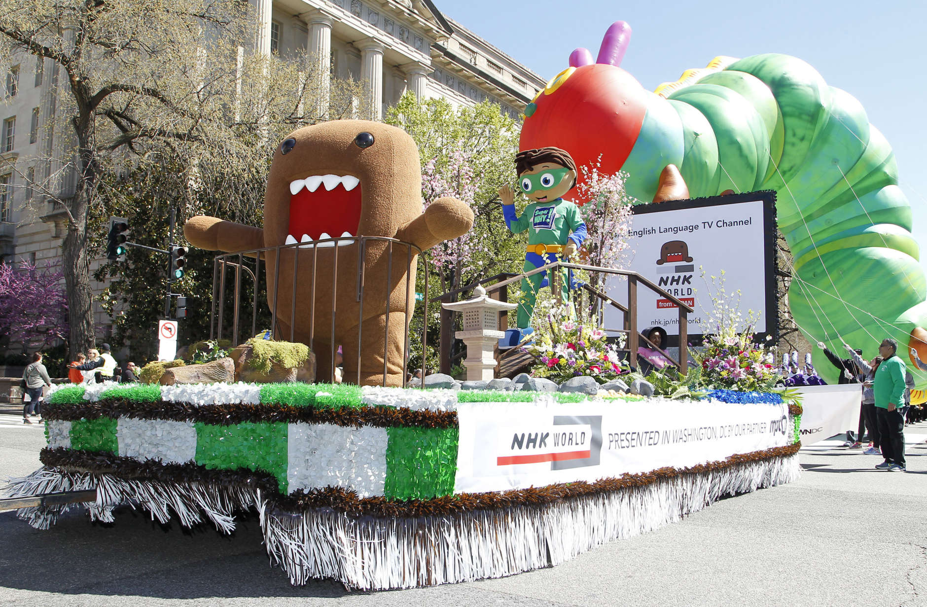 NHK WORLD TV's mascot Domo, left, and PBS Kids animated TV series character, Super Why!, right, on NHK WORLD TV's float during The National Cherry Blossom Festival Parade on Saturday, April 8, 2017 in Washington. (AP Images for NHK WORLD TV/Paul Morigi)