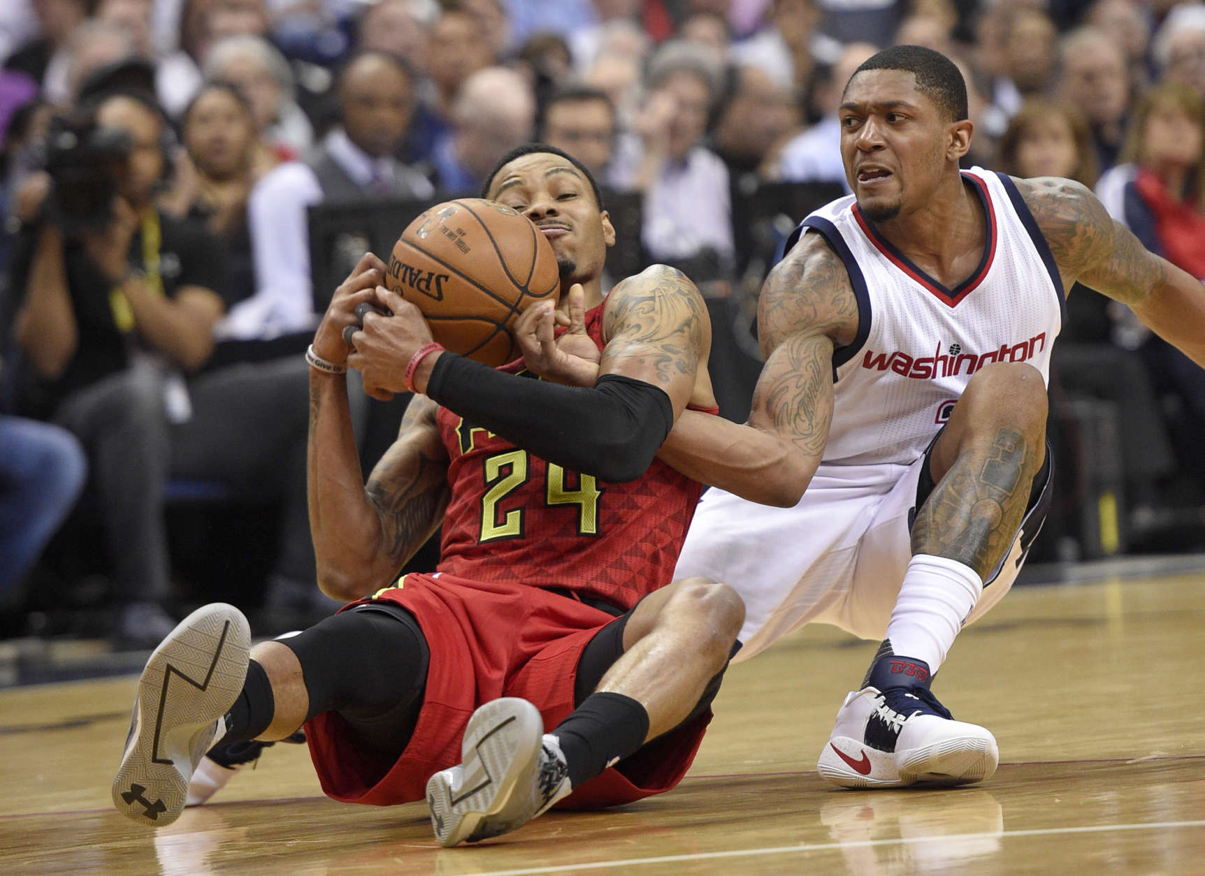 Washington Wizards guard Bradley Beal, right, battles for the ball against Atlanta Hawks forward Kent Bazemore (24) during the first half in Game 5 of a first-round NBA basketball playoff series, Wednesday, April 26, 2017, in Washington. (AP Photo/Nick Wass)