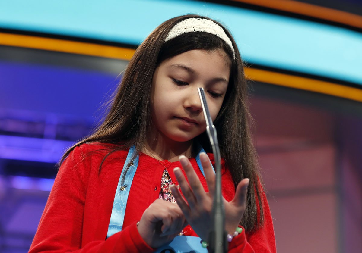 Melodie Loya, 12, from Bainbridge, N.Y., uses her hand as and imaginary paper and pen to spell her word during the finals of the 90th Scripps National Spelling Bee, Thursday, June 1, 2017, in Oxon Hill, Md. (AP Photo/Alex Brandon)